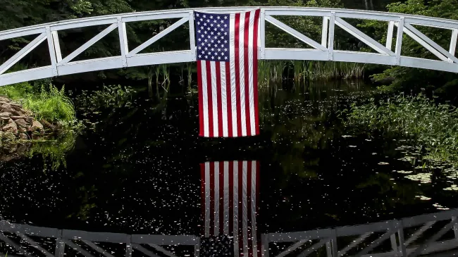 An American flag hangs off a walking bridge