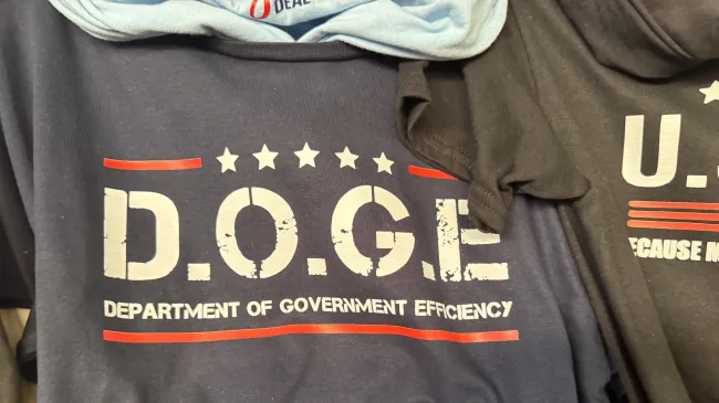 A stack of DOGE t-shirts