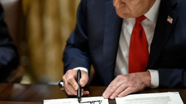 Trump signs a mineral agreement during a bilateral meeting