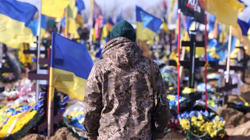 Ukraine war memorial with headstones, flags, and flowers