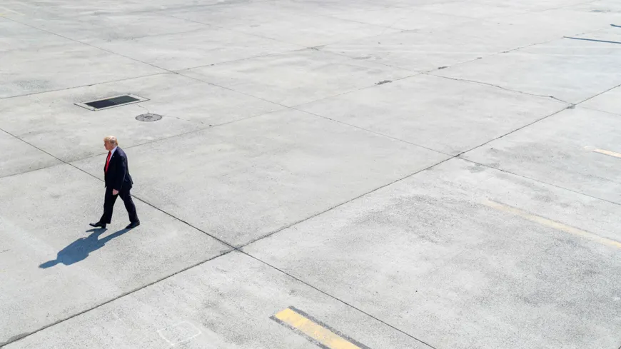 Trump walks along the tarmac